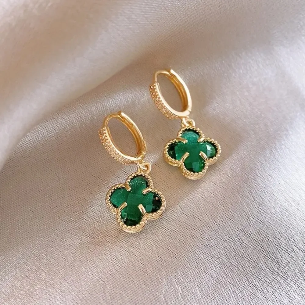 clover-shaped dangle earrings featuring green stones and gold plating with paved